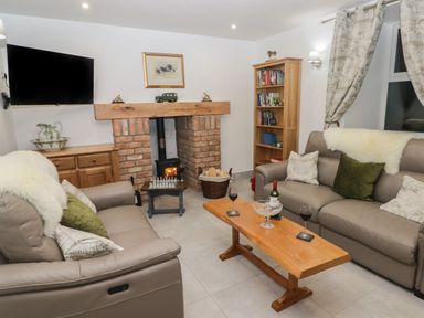 A living room with sofas a wooden coffee table and a fireplace at Little Pale Near Whitland