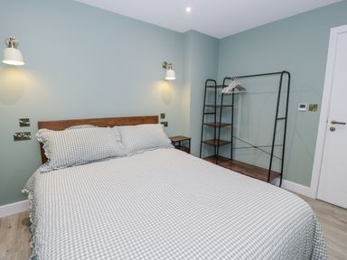 A bedroom with a bed and clothes rack at Frongoch Old Power House in Dolgellau