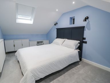 A bedroom with a bed and cupboard at Frongoch Old Power House in Dolgellau