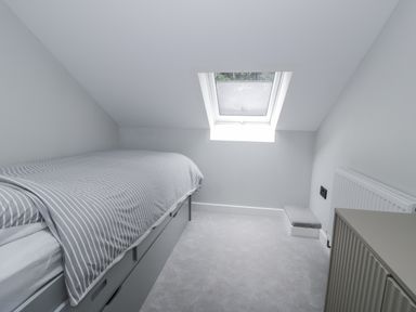 A bedroom with a bed and window at Frongoch Old Power House in Dolgellau