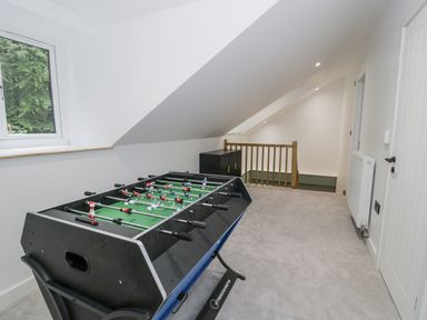 A game room with a foosball table and window at Frongoch Old Power House in Dolgellau