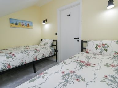 A bedroom with two beds and a door at Frongoch Old Power House Dolgellau