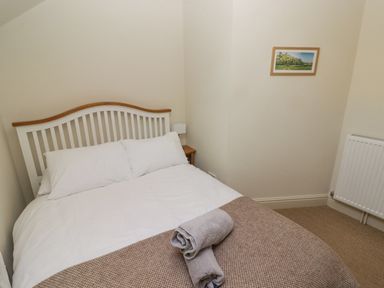 A bedroom with a bed folded towels on a blanket and a picture on the wall at Clearbrook Lodge in Llanarthney nr Llandeilo Carmarthenshire