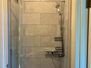 A shower with tiled walls at Clearbrook Lodge in Llanarthney, nr Llandeilo, Carmarthenshire