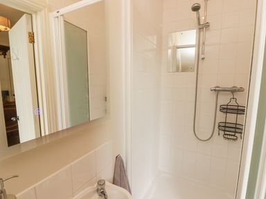A bathroom with a sink countertop mirror and a shower at Meadow Cottage in Llanarthney nr Llandeilo Carmarthenshire