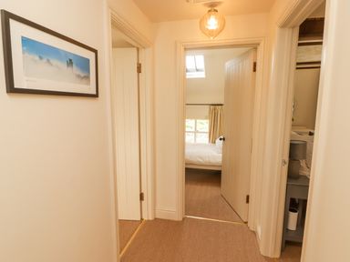 A hallway with beige carpet and cream walls leading to bedrooms at Meadow Cottage in Llanarthney nr Llandeilo Carmarthenshire