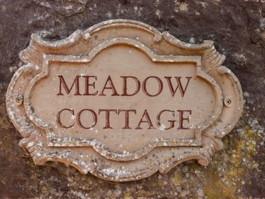 A decorative plaque with the words Meadow Cottage on a stone wall at Meadow Cottage in Llanarthney nr Llandeilo Carmarthenshire