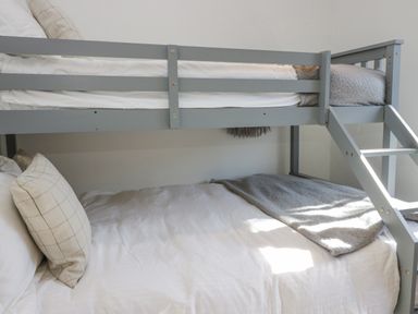 A gray bunk bed with white bedding and plaid pillows in a bedroom at Lakeland View Ambleside 86 White Cross Bay near Windermere