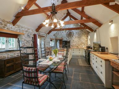 A kitchen with a table and chairs at St Dogwells Barn near Wolfscastle