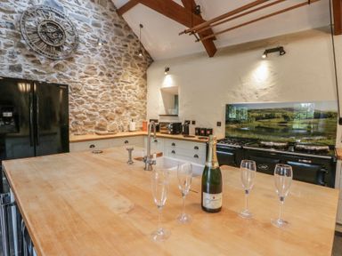 A kitchen with a wooden island and appliances at St Dogwells Barn near Wolfscastle