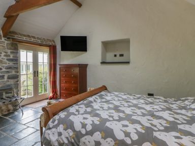 A bedroom with a bed and a dresser at St Dogwells Barn near Wolfscastle