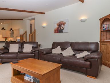 A living room with two brown leather sofas a wooden coffee table and a wooden cabinet at Binneford Barn Kennerleigh near Cheriton Fitzpaine