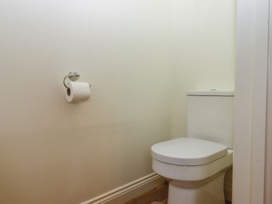 A bathroom with a toilet and a toilet paper holder on a wall at Binneford Barn in Kennerleigh near Cheriton Fitzpaine
