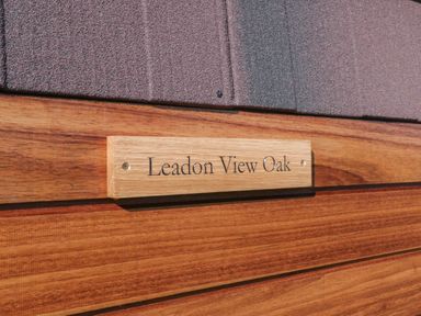 A wooden sign with the text Leadon View Oak mounted on a wooden wall