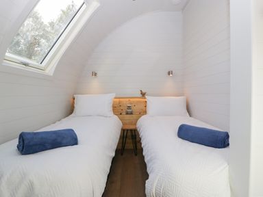 A bedroom with two single beds each with a blue towel a wooden headboard and a skylight window at Leadon View Oak in Upleadon near Newent