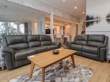 A living room with two leather sofas and a wooden coffee table at The Lodge @ Racecourse House Babell near Holywell