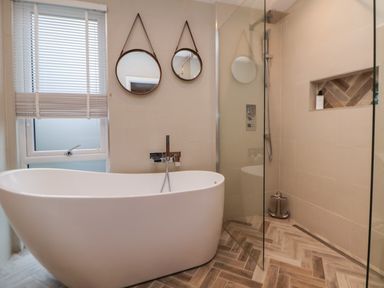 A bathroom with a freestanding bathtub two round mirrors and a walk in shower at The Lodge @ Racecourse House Babell near Holywell