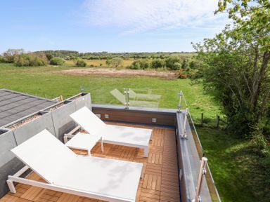 An outdoor terrace with lounge chairs at The Lodge @ Racecourse House in Babell near Holywell