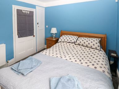 A bedroom with a double bed bedside tables and folded towels on the bed at Rushfield in St Dogmaels North Pembrokeshire