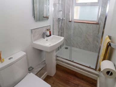 A bathroom with a toilet sink shower and towel at Rushfield in St Dogmaels North Pembrokeshire