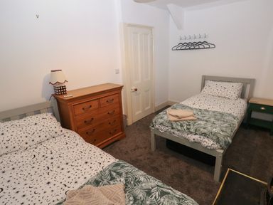 A bedroom with two single beds a wooden chest of drawers and a small bedside table at Rushfield in St Dogmaels North Pembrokeshire