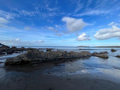A rocky shoreline with water and clouds at Rushfield in St Dogmaels North Pembrokeshire