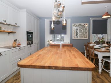 A kitchen with an island and dining area at The Wonky Nest in Bowness-On-Windermere