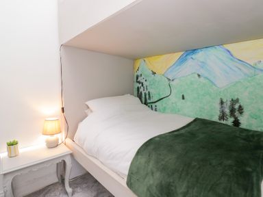 A bedroom with a bed and a wall mural at The Wonky Nest in Bowness-On-Windermere