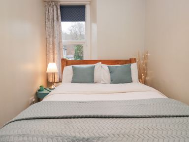 A bedroom with a bed and bedside lamp at The Wonky Nest in Bowness-On-Windermere