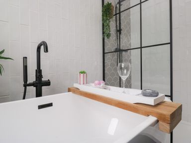 A bathroom with a bathtub and black faucet at The Wonky Nest in Bowness-On-Windermere