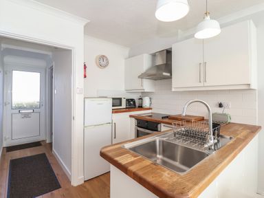 A kitchen with a sink countertop and appliances at Beachcomber Maer near Bude