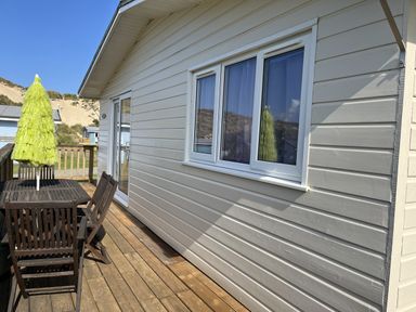 A deck with a table and chairs at Chalet 3 Wipeout in Hayle