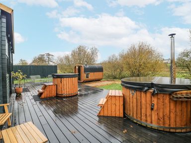 An outdoor area with a hot tub and barrel sauna at Badger's Burrow in Edith Weston
