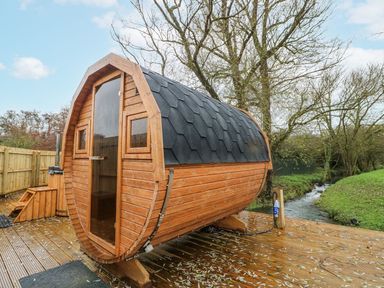A wooden cabin located by a stream at Badger's Burrow in Edith Weston