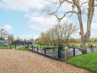 An outdoor area with a tree and seating at Badger's Burrow in Edith Weston
