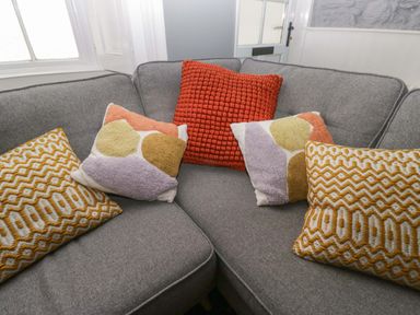A sofa with patterned cushions at Unicorn Cottage