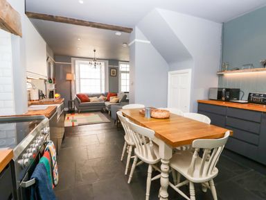 A kitchen with dining table and seating area at Unicorn Cottage in 