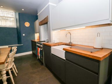 A kitchen with a sink and stove at Unicorn Cottage