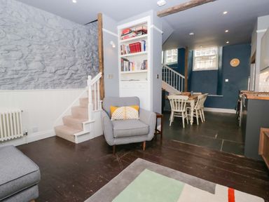 A living room with a sofa and stairs at Unicorn Cottage