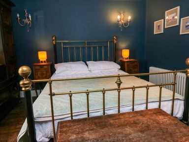 A bedroom with a bed and nightstands at Unicorn Cottage