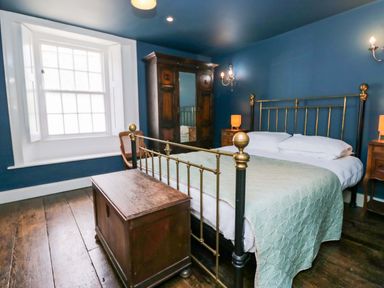 A bedroom with a bed and wardrobe at Unicorn Cottage
