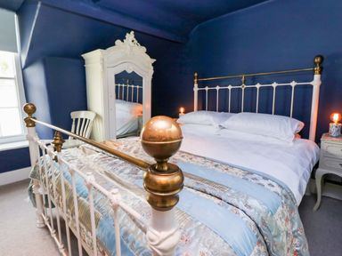 A bedroom with a bed and wardrobe at Unicorn Cottage