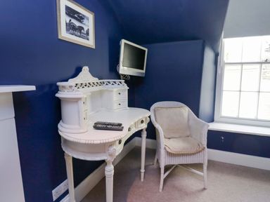 A study with a desk, chair, and television at Unicorn Cottage