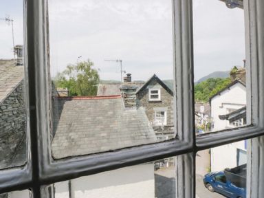 A view of rooftops and buildings from a window at Unicorn Cottage in 