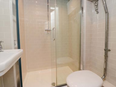 A bathroom with a shower, sink, and toilet at Unicorn Cottage in 