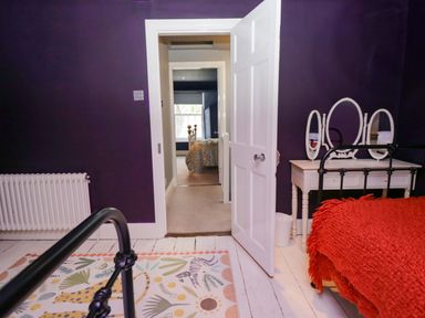 A bedroom with a bed and a mirror at Unicorn Cottage