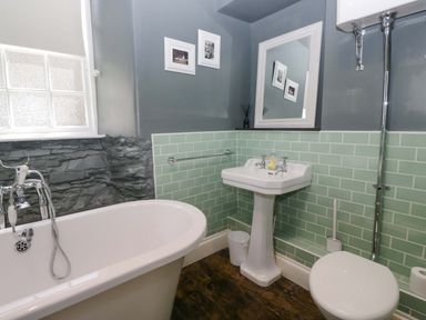 A bathroom with a bathtub and sink at Unicorn Cottage