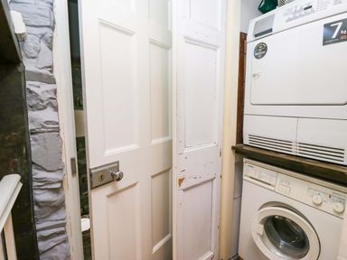 A laundry room with a washing machine and dryer at Unicorn Cottage