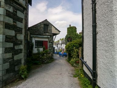 An alley with stone and wooden buildings at Unicorn Cottage in 