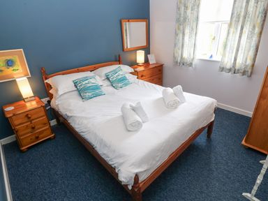 A bedroom with a double bed and bedside tables with lamps at Chy Lowena Goldenbank near Budock Water